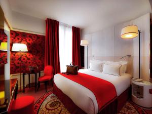 Cette chambre comprend un grand lit et des rideaux rouges. dans l'établissement Hotel Carlton Lyon - MGallery Hotel Collection, à Lyon