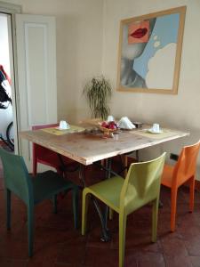 una mesa de comedor con sillas y una pintura en Alloggio della Villetta en Palazzolo sullʼOglio