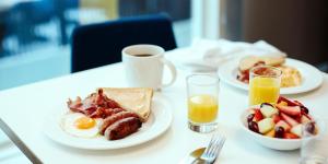 stół z dwoma talerzami jedzenia śniadaniowego i soku pomarańczowego w obiekcie Holiday Inn - Fort Worth - Alliance, an IHG Hotel w mieście Fort Worth