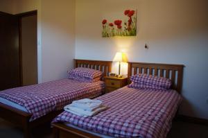 two beds in a hotel room with towels on them at Llanerchindda Farm Guest House in Cynghordy
