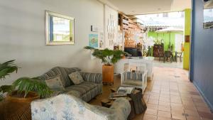 uma sala de estar com dois sofás e uma mesa em Hostal Paraiso Tayrona em Santa Marta