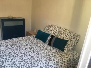 a bedroom with a bed with a black and white comforter at Coeur de village in Bormes-les-Mimosas