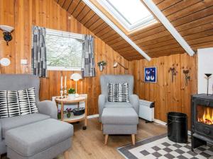 a living room with two chairs and a fireplace at 6 person holiday home in Toftlund in Arrild
