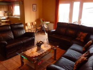 un soggiorno con divani in pelle e tavolino da caffè di Cozy Cottage in Baugnez Malmedy with Sauna a Malmedy