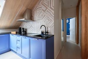 una cocina con armarios azules y una pared geométrica en Dream Boutique Apartments en Riga