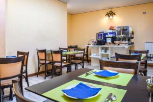 a dining room with tables and chairs with blue napkins at Camere America B&B in Sirmione