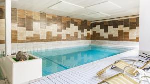 a large swimming pool with a tile wall at Ob Vierwaldstättersee in Emmetten