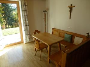 une salle à manger avec une table et une croix sur le mur dans l'établissement Ferienwohnung Am Kirchberg, à Achslach