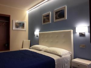 a bedroom with a bed with a blue wall at Al Castello in Milazzo