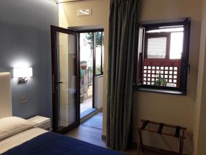 a bedroom with a bed and a window and a door at Al Castello in Milazzo