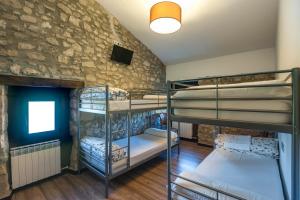 Cette chambre dispose de 3 lits superposés et d'un mur en pierre. dans l'établissement Albergue turístico "La Fábrica", à Tardajos