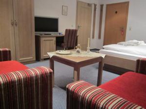 a hotel room with a bed and a table and chairs at Wellnesshotel Bürgerstuben in Willingen +43 photos