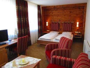 a hotel room with a bed and two chairs at Wellnesshotel Bürgerstuben in Willingen