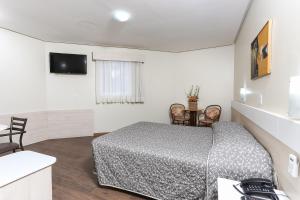 a bedroom with a bed and a television in it at Hotel Express Centro Histórico in Porto Alegre