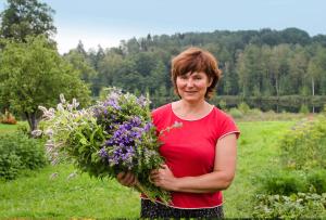 a woman holding a bunch of flowers in a field at Meza Skuki in Vabole