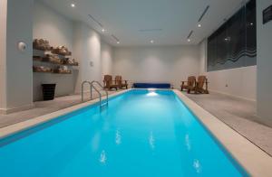 a pool with blue water in a room with chairs at Microtel Inn & Suites by Wyndham Irapuato in Irapuato