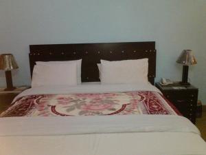 Hāji Bāba的住宿－Hotel Hilton Palace，卧室配有一张白色大床和花卉床罩
