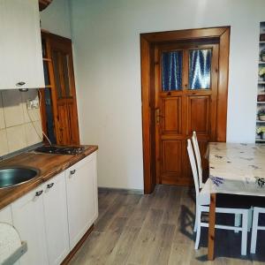 a kitchen with a sink and a wooden door at Drevenica Raj in Bystrička