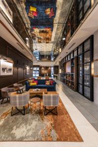 a lobby with a blue couch and a table and chairs at Hotel Indigo Tulsa DWTN/Entertainment Area in Tulsa