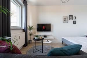 een woonkamer met een bed en een tafel met een tv bij Marvlex #1 - Studio mit WIFI und NETFLIX in Celle