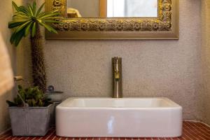 a white sink with a gold faucet in a bathroom at Villa Orange, small house in a pine forest in Kostrena +15 photos