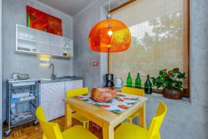 a kitchen with a wooden table and yellow chairs at Villa Orange, small house in a pine forest in Kostrena