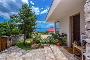 a home with a stone wall and a patio at Villa Orange, small house in a pine forest in Kostrena
