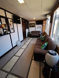 a living room with two couches and a room with at Toucan Hostel in Alajuela City