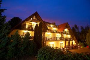 uma casa grande com luzes acesas à noite em Afrodyta SPA & Wellness Resort em Ośno Lubuskie