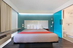 a hotel room with a bed and a bathroom at Solo Motel Broadway in Los Angeles