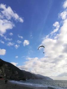 a person is flying a kite on the beach at I Lecci Di Soviore in Monterosso al Mare
