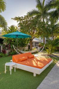 ein großes Bett mit einem Sonnenschirm und einem Stuhl in der Unterkunft The Vagabond Hotel in Miami