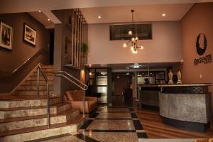 un vestíbulo de un hotel con escaleras y un bar en Regente Hotel, en Pato Branco
