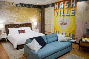 a bedroom with a bed and a blue couch at 506 Lofts in Nashville