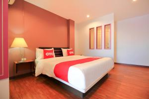 a bedroom with a large bed with red and white pillows at Super OYO 117 King One Suvarnabhumi in Bangkok