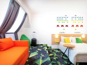 a hotel room with a bed and a couch at Ibis Styles Budapest Center in Budapest