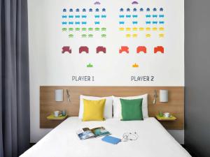 a bedroom with a bed with books on it at Ibis Styles Budapest Center in Budapest