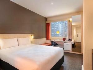 um quarto de hotel com uma cama grande e uma casa de banho em ibis Wellington em Wellington