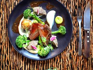 a plate of food with meat and broccoli on a table at ibis Wellington in Wellington