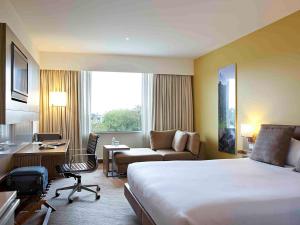 オークランドにあるノボテル オークランド エラースリーの大きなベッドとデスクが備わるホテルルームです。