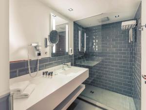 a bathroom with a sink, mirror, and bathtub at Mercure Hotel & Residenz Berlin Checkpoint Charlie in Berlin