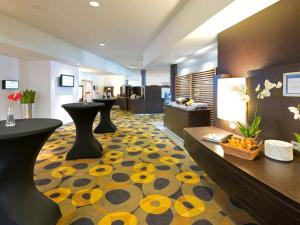 a hotel lobby with a yellow and black carpet at Novotel Leuven Centrum in Leuven