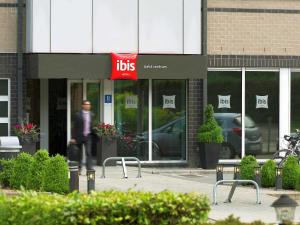 un hombre caminando delante de una tienda de regalos en ibis Aalst en Aalst