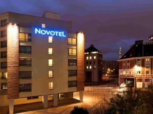 un hôtel avec un panneau sur le côté d'un bâtiment dans l'établissement Novotel Lille Centre Gares, à Lille