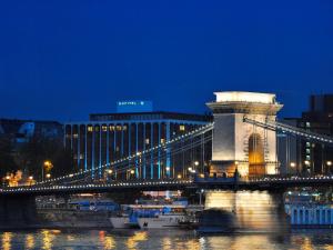un puente sobre un río por la noche con un edificio en Sofitel Budapest Chain Bridge, en Budapest