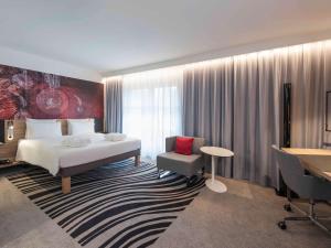 a hotel room with a large bed and a television at Novotel München City in Munich
