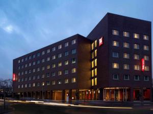 a black building with red signs on the side of it at ibis Hamburg Alsterring in Hamburg