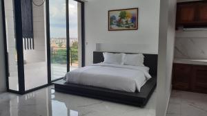 a bedroom with a white bed and a large window at LY Residence Suite & Apartment in Siem Reap