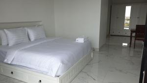 a bedroom with a large bed with white sheets at LY Residence Suite & Apartment in Siem Reap