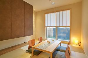 a dining room with a table and chairs and a window at 凜庵 LIAN_KANAZAWA in Kanazawa
